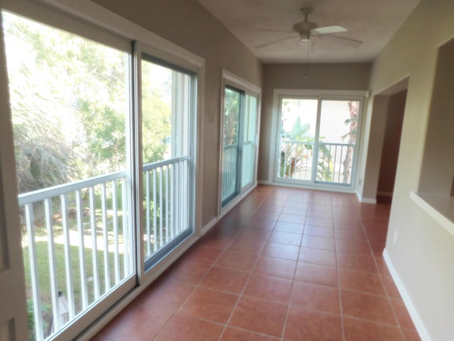 unfurnished sunroom with ceiling fan