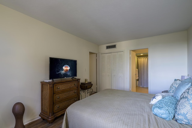 bedroom with a closet, hardwood / wood-style flooring, and ensuite bath