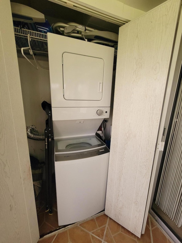 laundry room featuring stacked washer and clothes dryer and tile patterned floors