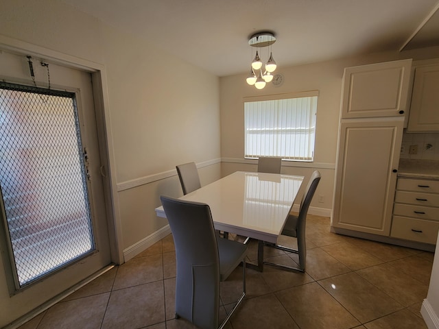 dining space featuring light tile patterned floors and a notable chandelier