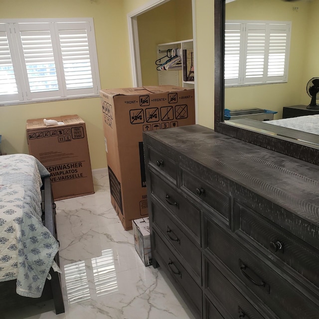 bedroom featuring marble finish floor and multiple windows