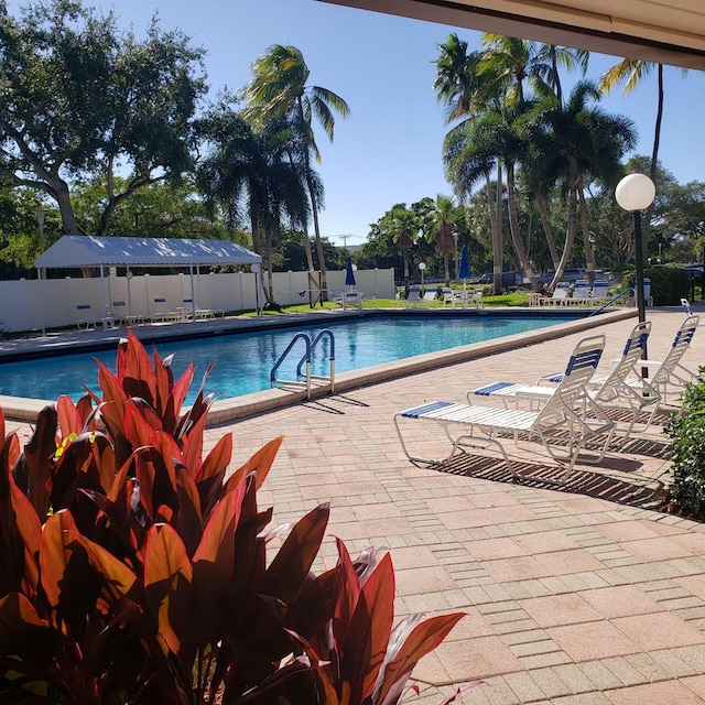 pool featuring fence and a patio