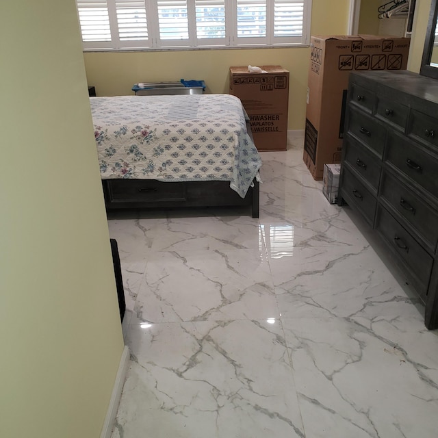 bedroom featuring marble finish floor