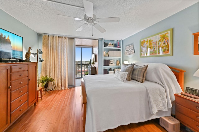 bedroom with ceiling fan, light wood-type flooring, access to outside, and a textured ceiling