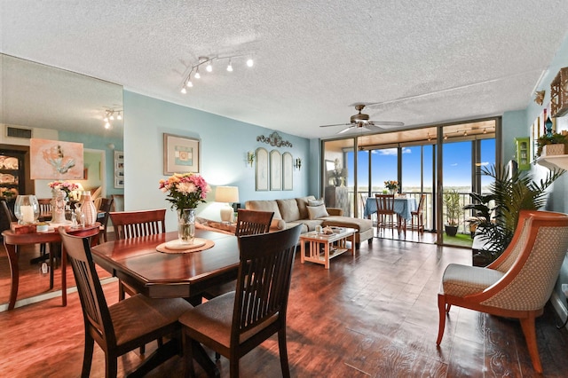 dining room with rail lighting, a textured ceiling, ceiling fan, and expansive windows