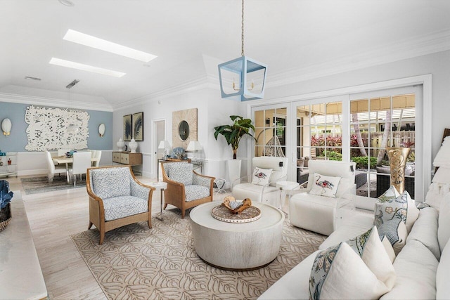 living room featuring light hardwood / wood-style floors, a skylight, ornamental molding, and a chandelier