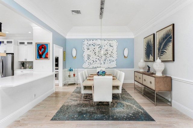 dining area featuring crown molding and light hardwood / wood-style flooring