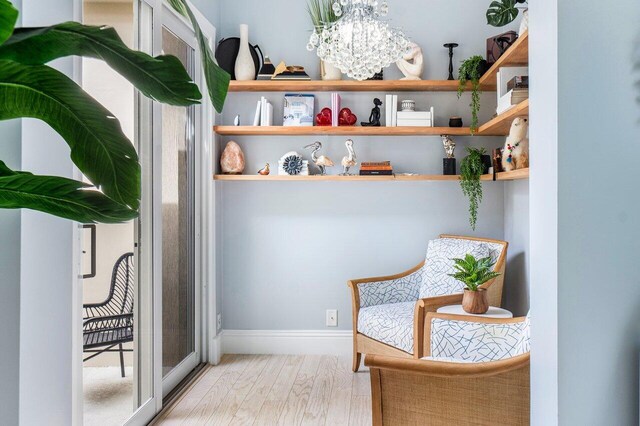 living area featuring a notable chandelier and light hardwood / wood-style floors