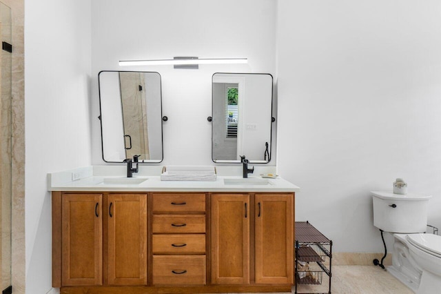 bathroom featuring toilet, a shower with shower door, and vanity