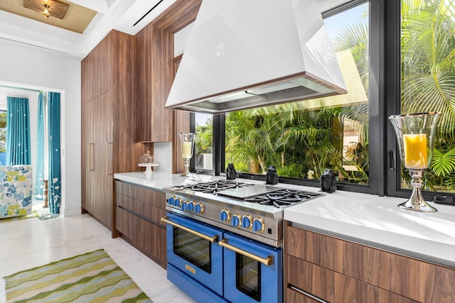 kitchen featuring double oven range, custom exhaust hood, light countertops, modern cabinets, and marble finish floor