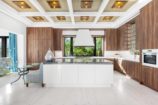 kitchen with brown cabinets, white oven, marble finish floor, modern cabinets, and a sink