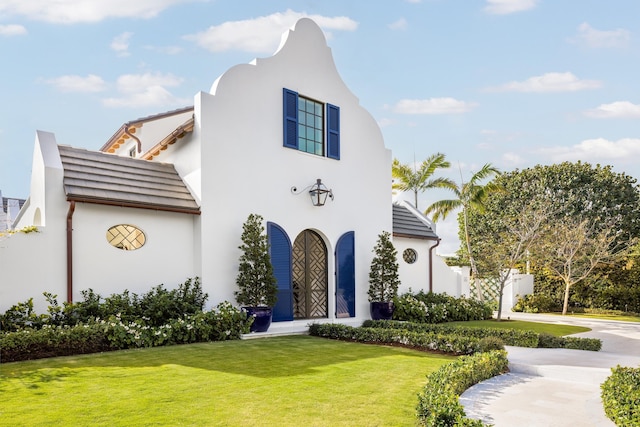 view of front of home with stucco siding and a front yard