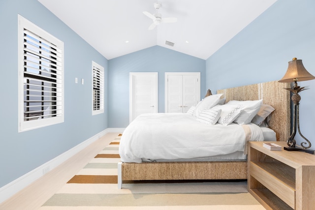 bedroom with visible vents, a ceiling fan, wood finished floors, baseboards, and vaulted ceiling