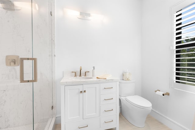 bathroom featuring a marble finish shower, toilet, vanity, and baseboards