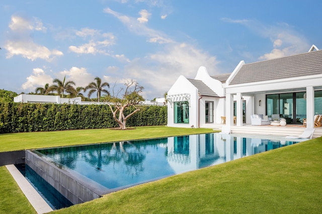 view of pool with an outdoor hangout area, a lawn, an infinity pool, and a patio area