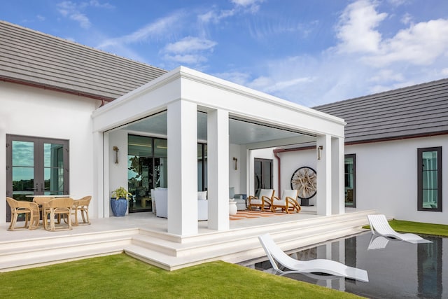 rear view of house featuring french doors and stucco siding