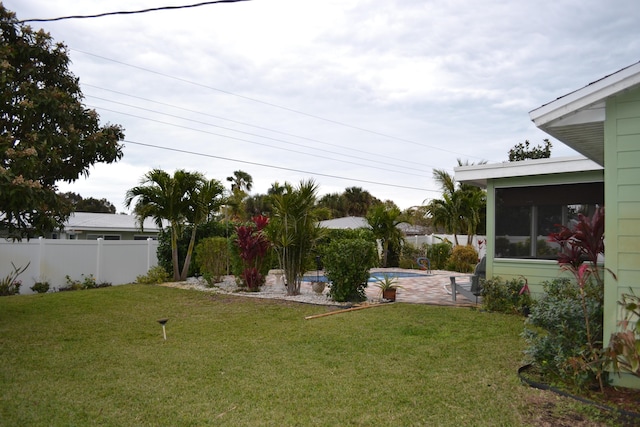 view of yard with a fenced in pool, a patio, and a sunroom