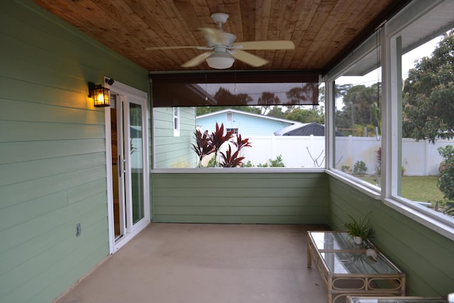 unfurnished sunroom featuring wooden ceiling, plenty of natural light, and ceiling fan