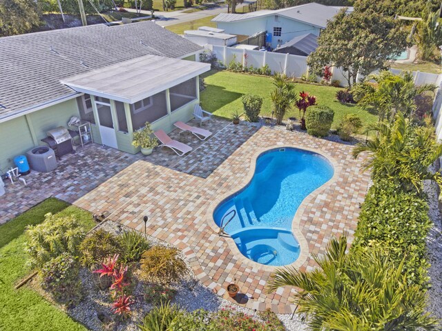 view of swimming pool with a yard, a sunroom, and a patio area