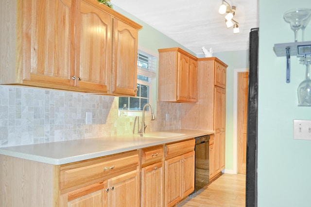 kitchen featuring light wood-type flooring, decorative backsplash, sink, and black dishwasher