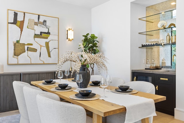 dining space with sink and light wood-type flooring