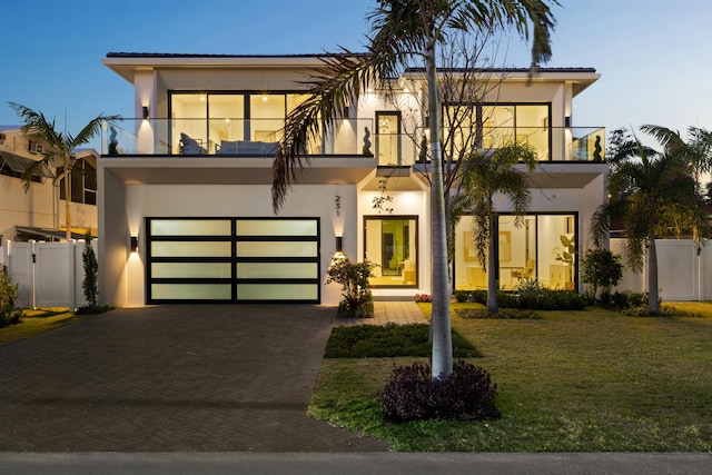 contemporary house with a front yard and a balcony