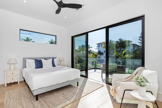 bedroom with multiple windows, access to exterior, ceiling fan, and hardwood / wood-style flooring