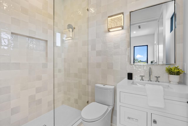 bathroom featuring toilet, tiled shower, tile walls, and vanity