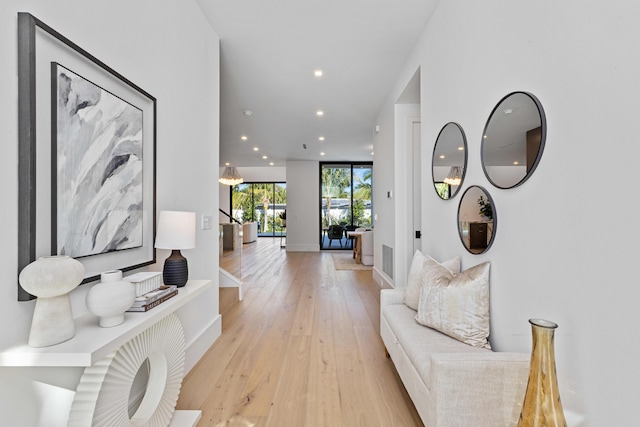 hallway with light hardwood / wood-style floors and expansive windows