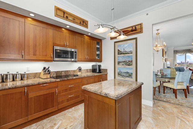 kitchen with black electric cooktop, decorative light fixtures, crown molding, and a kitchen island