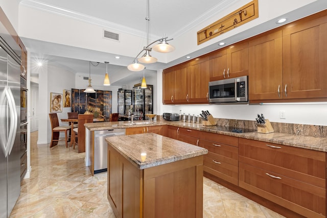 kitchen featuring a center island, kitchen peninsula, hanging light fixtures, light stone countertops, and appliances with stainless steel finishes