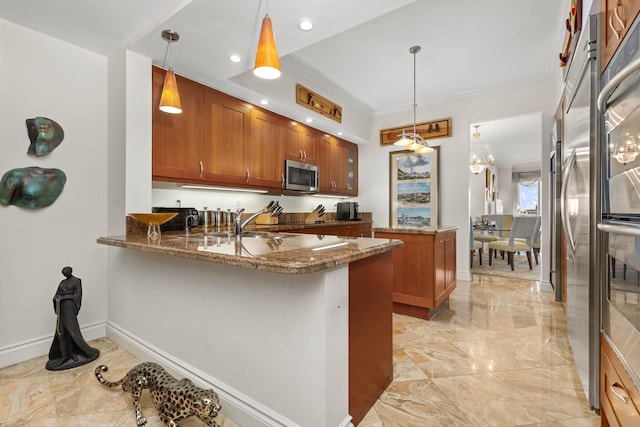 kitchen featuring kitchen peninsula, stainless steel appliances, dark stone counters, and pendant lighting