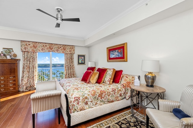 bedroom with dark hardwood / wood-style flooring, ceiling fan, crown molding, and a water view