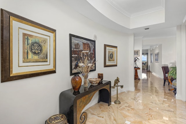 hallway with a tray ceiling and crown molding