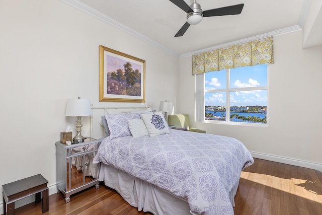 bedroom featuring ceiling fan, dark wood-type flooring, ornamental molding, and a water view