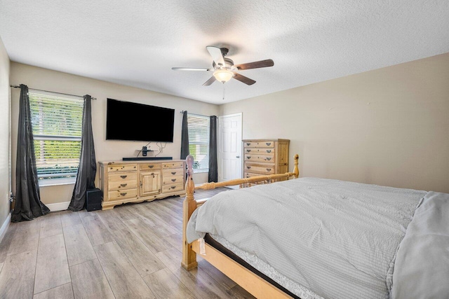 bedroom featuring a textured ceiling, ceiling fan, and light hardwood / wood-style floors