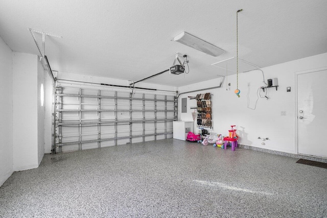 garage featuring electric panel and a garage door opener