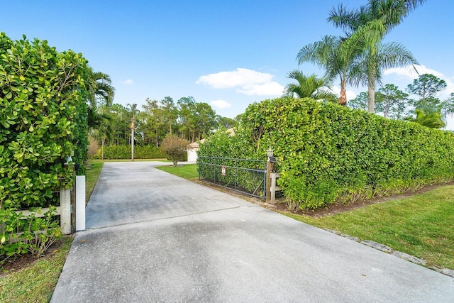 view of gate with a lawn