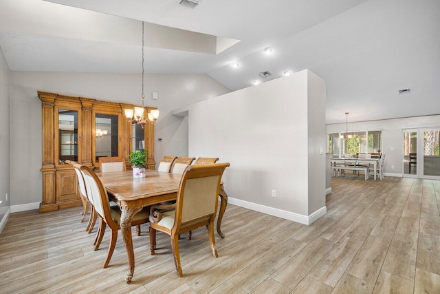 dining area with lofted ceiling, an inviting chandelier, and light wood-type flooring