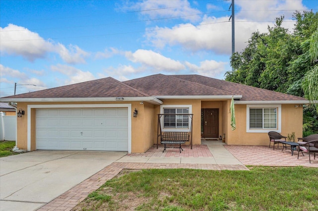 single story home with a patio, a front yard, and a garage