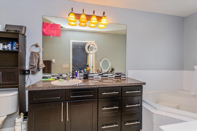 bathroom featuring toilet, vanity, and tiled tub