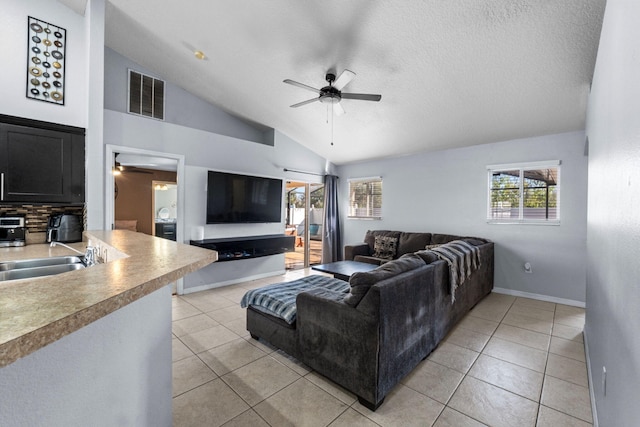 living room with vaulted ceiling, visible vents, ceiling fan, and light tile patterned floors