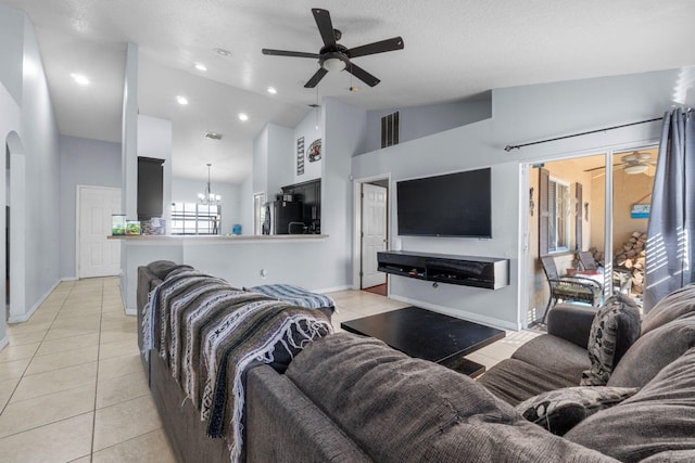 living area with ceiling fan with notable chandelier, light tile patterned flooring, and visible vents