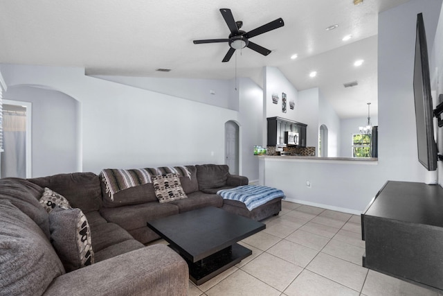 living area featuring arched walkways, light tile patterned floors, recessed lighting, vaulted ceiling, and ceiling fan with notable chandelier