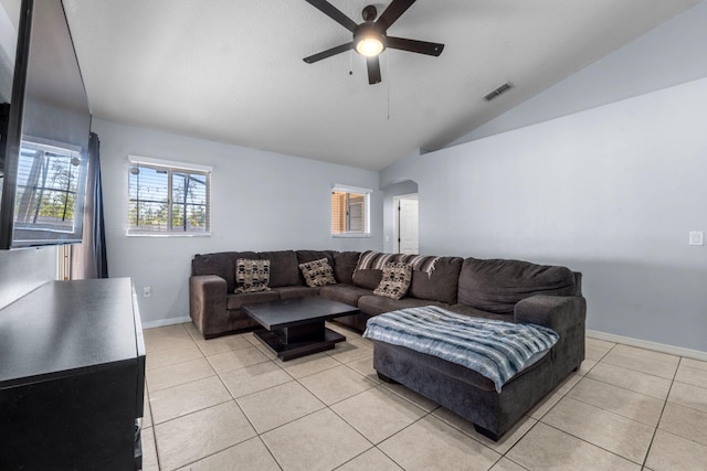 living room featuring light tile patterned floors, vaulted ceiling, visible vents, and arched walkways