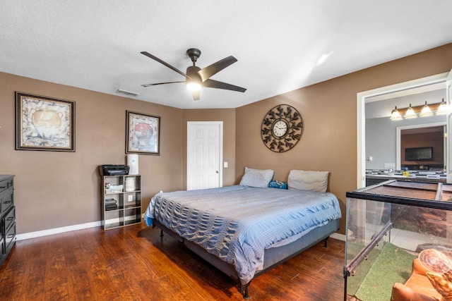 bedroom with a ceiling fan, wood finished floors, visible vents, and baseboards