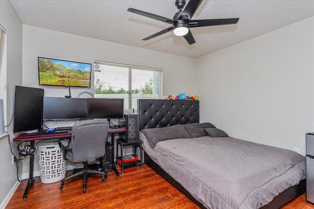 bedroom featuring hardwood / wood-style floors, a textured ceiling, and ceiling fan