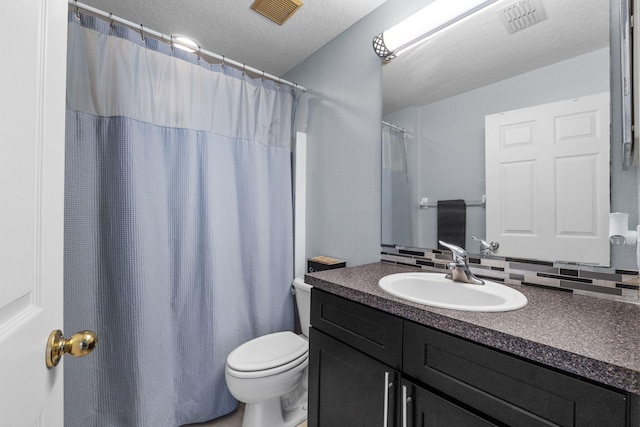 bathroom featuring toilet, visible vents, a textured ceiling, and vanity