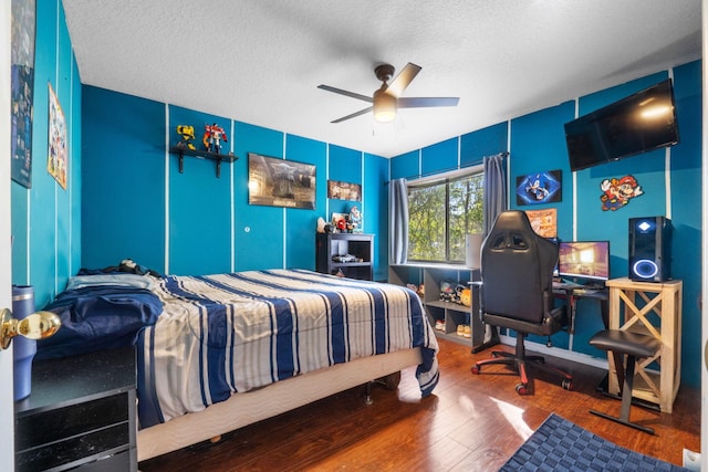 bedroom featuring a textured ceiling, a ceiling fan, and wood finished floors