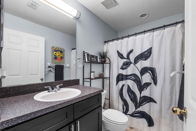 full bathroom with a textured ceiling, toilet, vanity, and visible vents